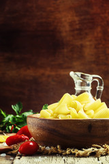 Castellane Dried pasta in a bowl, olive oil, tomatoes, garlic an