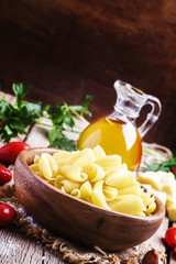 Castellane Dried pasta in a bowl, olive oil, tomatoes, garlic an