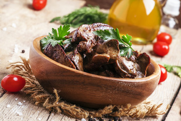 Fried chicken livers in a bowl, vintage wooden background, selec