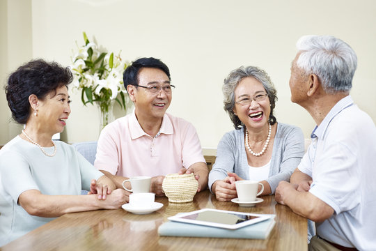 senior asian friends relaxing chatting at home