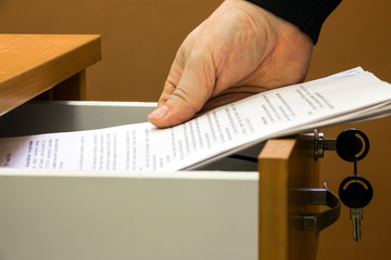Man puts or takes the documents from the drawer