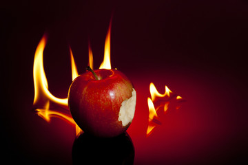 One sinful bite from apple with flames