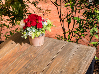rose artificial flowers in the pot , on the wood desk, in the ga - obrazy, fototapety, plakaty