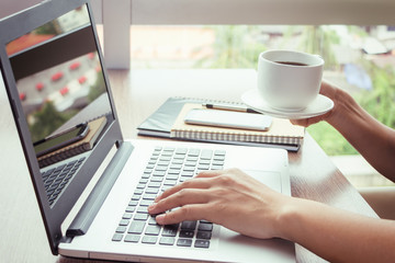 Close Up of woman hands using mobile phone and laptop computer with blank copy space screen for your advertising text message or content business in the Vintage effect.