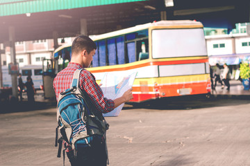 Young man standing looking map,Backpack Exploring Destination Ca