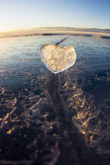 Naklejka premium Icy heart in a crack in the light of sunset. lake Baikal