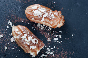 Tasty eclairs on table