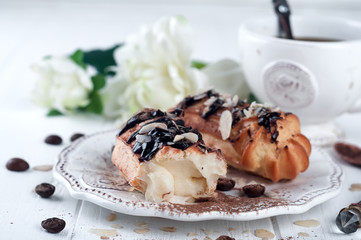 Tasty eclairs on table