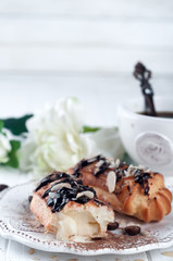 Tasty eclairs on table