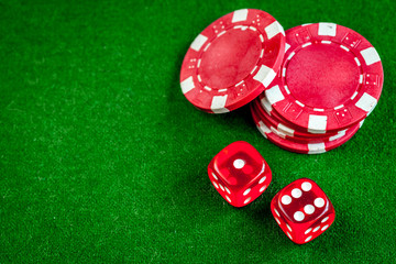 poker chips and dice on green background top view