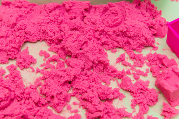 Kinetic Sand In A Heap For Indoor Game Or Children Creativity. Forms for the construction of the kinetic and pink sand scattered on the table.