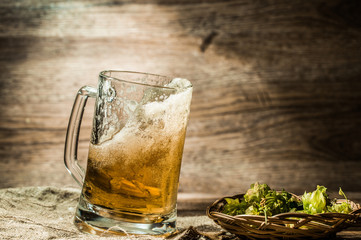 Beer spills from cup on wooden table