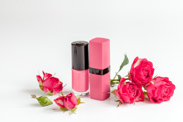 berry color decorative cosmetics with roses white background close up