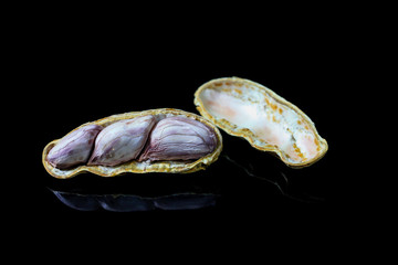 Naklejka premium Peeled peanut on black background.