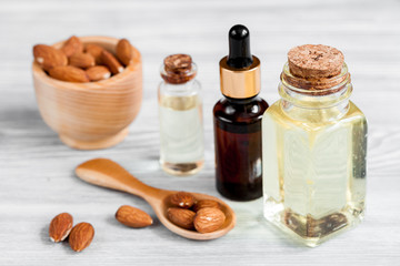 Obraz na płótnie Canvas cosmetic almond oil in glass bottle on wooden background