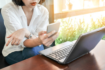 Asian entrepreneur working with a phone and laptop