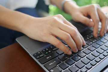 Woman's hands typing on laptop keyboard