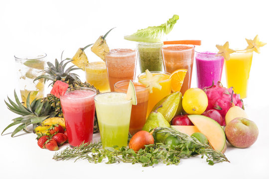 Fresh squeezed juice, many glasses on white background, fruits and veggies around, studio shoot.