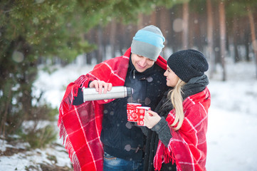 Couple under a blanket with a cup of hot tea or coffee