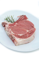 Bistecca di manzo con l'osso su piatto con rosmarino isolato su sfondo bianco