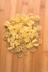 Wheat wagon wheel pasta isolated on a wood background