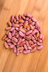 Pile of kidney beans isolated isolated on a wood background