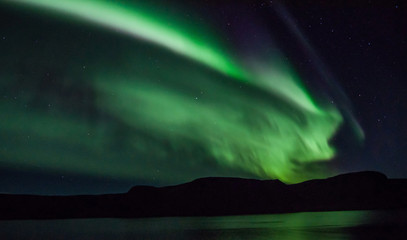 Northen lights (Aurora Borealis) in Iceland over the fjord