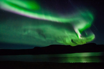 Northen lights (Aurora Borealis) in Iceland over the fjord