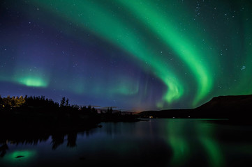 Northen lights (Aurora Borealis) in Iceland with mirroring on the lake