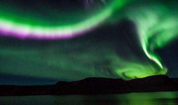 Northen lights (Aurora Borealis) in Iceland over the fjord