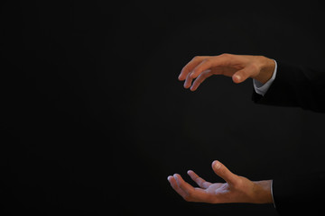 Male hands holding something on dark background