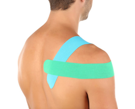 Physio tape on shoulder of sporty man isolated on white