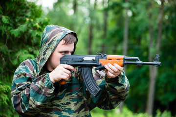 Armed soldier in camouflage with a Kalashnikov assault rifle, sh