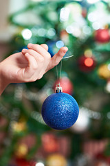Children's hand with blue Christmas toy ball