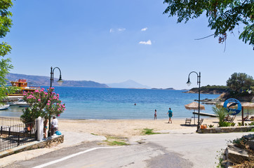 Small Greek village harbor on an Amoulani island, holy mountain Athos is in background, Chalkidiki, Macedonia, Greece