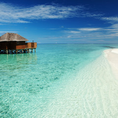 Tropical beach. Ocean waves and cloudy sky background. White san