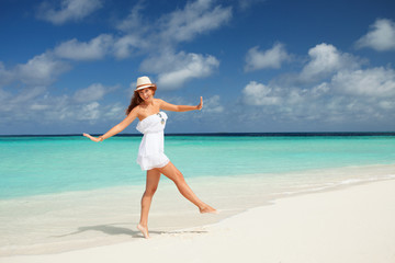 Fashion woman dancing on the beach. Happy island lifestyle. Whit