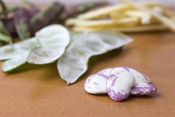 Grains of beetroot in the foreground, to the bottom pods of bean