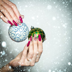 Female hands hold Christmas baubles