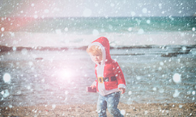 santa boy at sand beach water