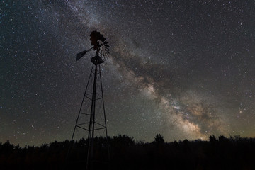 Old windmill with the milky way galaxy rising behind it 