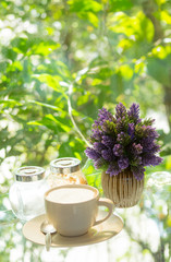 cup of coffee on glass table with nature background