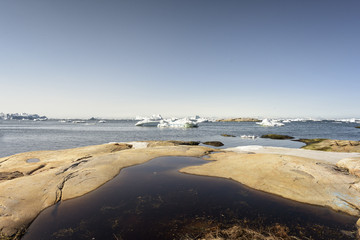 Arctic Icebergs Greenland in the arctic sea. You can easily see that iceberg is over the water surface, and below the water surface. Sometimes unbelievable that 90% of an iceberg is under water