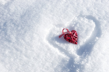 Red heart in heart on the fresh white snow