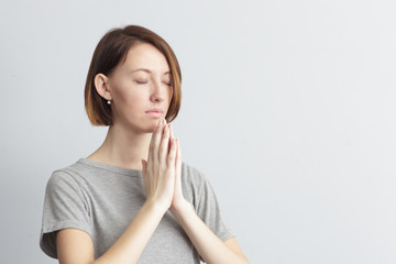 Girl holding hands together, elbows to the sides. Eyes closed.