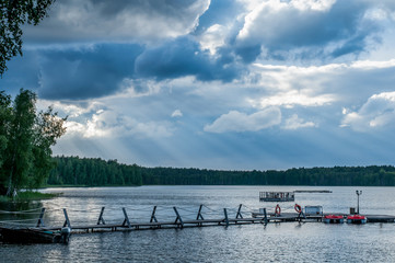 Calm heavenly landscape with thick clouds over the forest lake, quiet place to relax