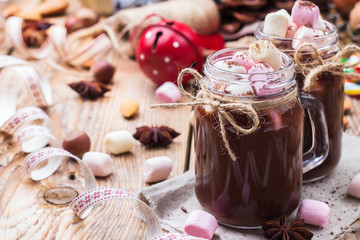 Hot chocolate with marshmallows and spices on christmas table
