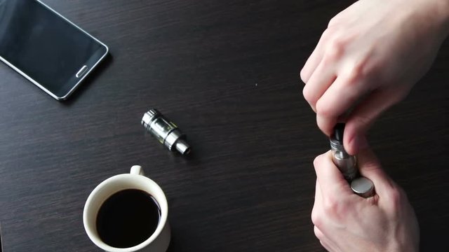 young man fills for liquid smoking electronic cigarette