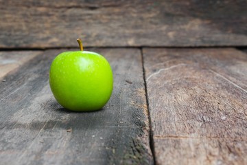 Green apple on wooden table  background