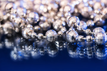 White pearl necklace isolated on black blue background.